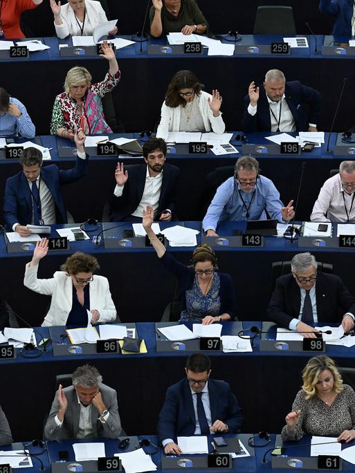 Viele der Mitglieder des Europaparlaments heben die Hände zur Abstimmung.