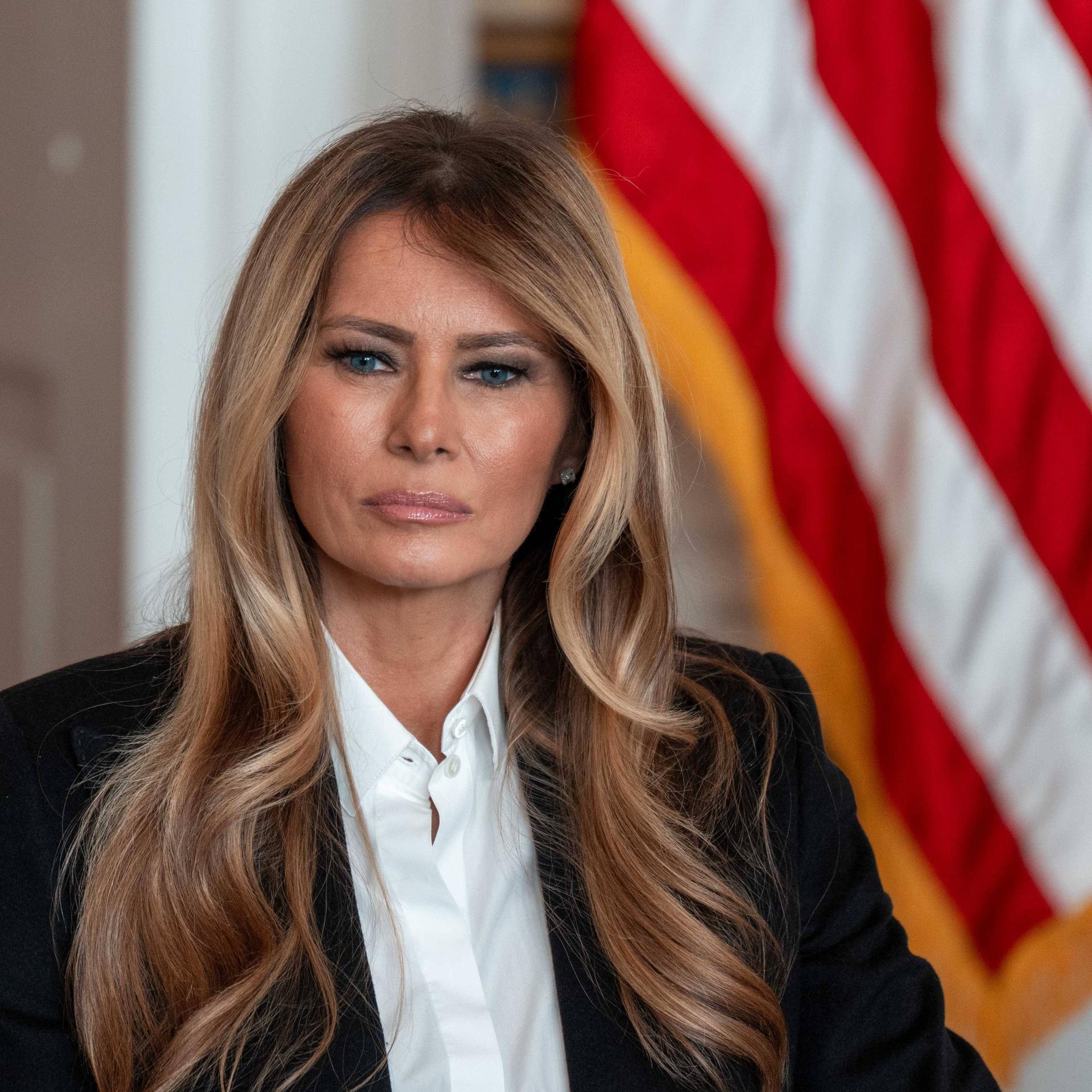 First Lady Melania Trump sitzt vor einer US-Flagge