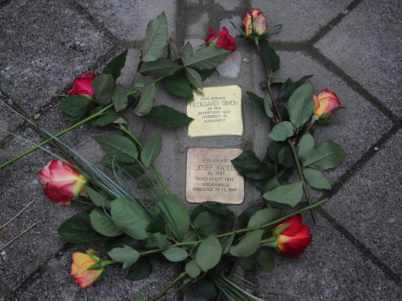 Vom Künstler Gunter Demnig frisch verlegte Stolpersteine mit Blumen in Magdeburg.