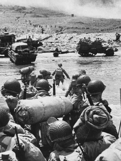 Amerikanische Truppen sitzen dicht gedrängt auf einer Fähre und bereiten sich auf die Landung in Omaha Beach vor.