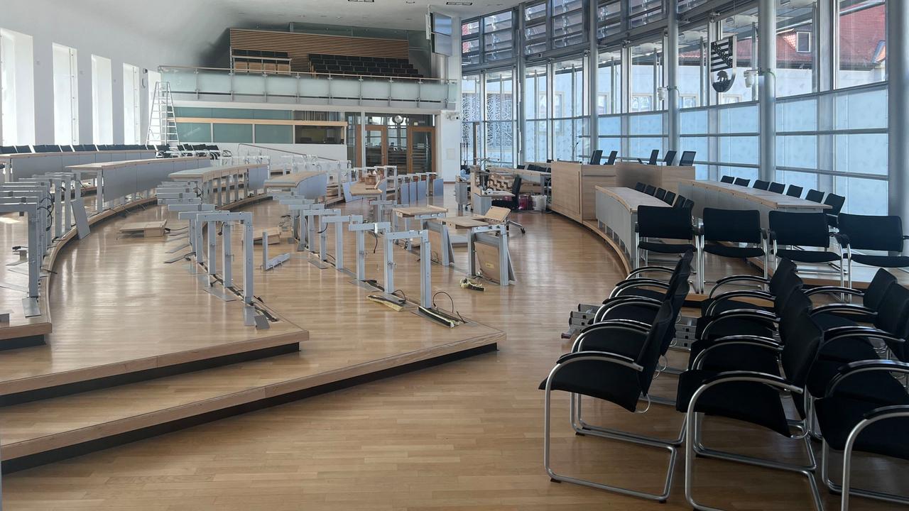 Blick in den Plenarsaal des Magdeburger Landtags. Auf der rechten Seite stehen Stühle, im Zentrum mehrere Tischgestelle ohne Tischplatten. Blick in den Plenarsaal des Magdeburger Landtags. Auf der rechten Seite stehen Stühle, im Zentrum mehrere Tischgestelle ohne Tischplatten.