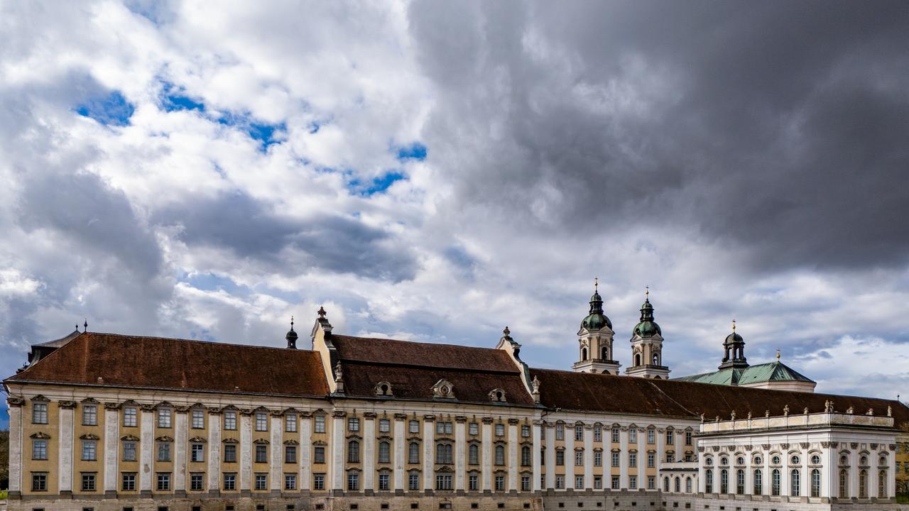 Ein riesiges barockes Klostergebäude samt Basilika mit Zwiebeltürmen vor Himmel und Wolken