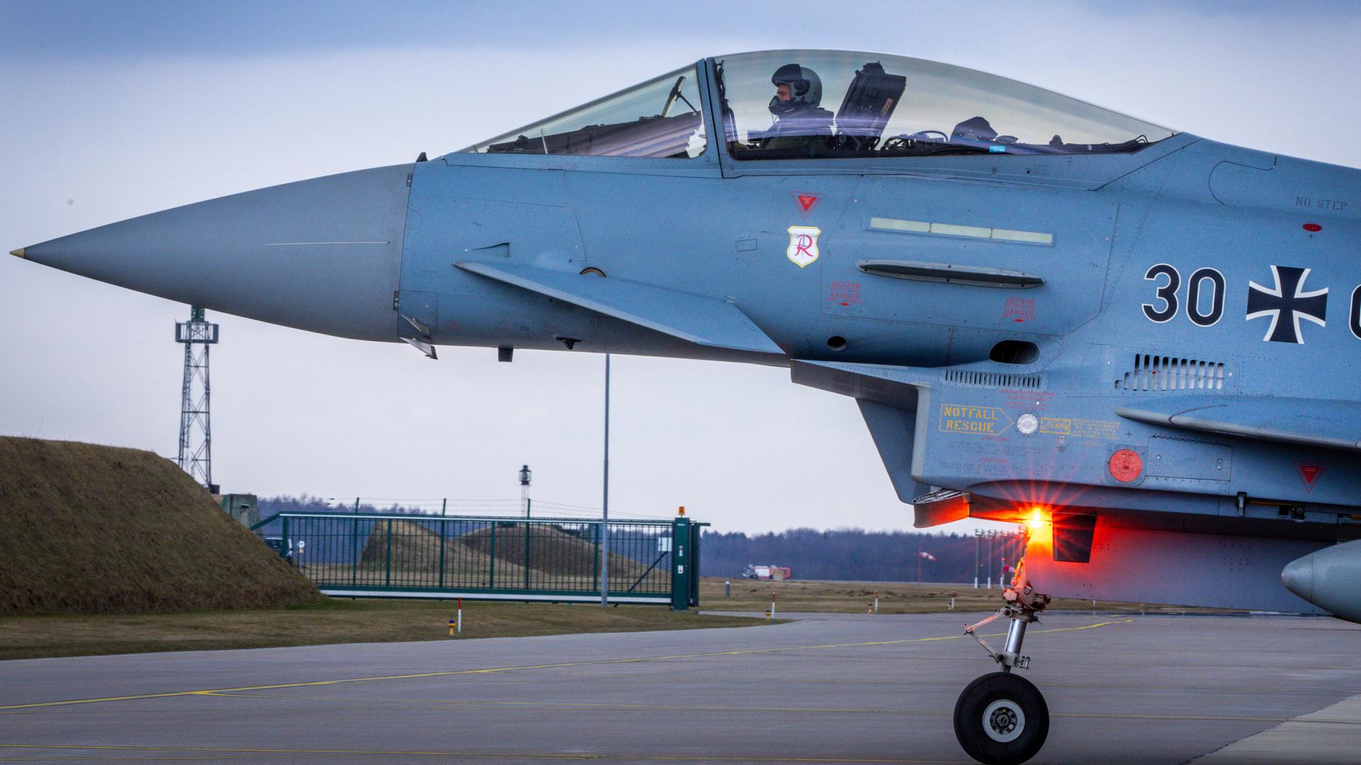 Ein Soldat sitzt in einem Eurofighter der Bundeswehr auf dem Fliegerhorst Laage und rollt zu Startbahn. 