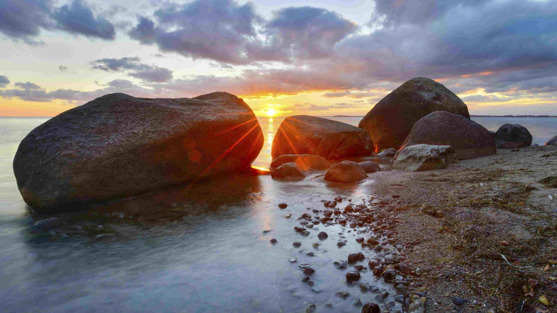 Große Findlinge am Strand der Ostsee bei Sonnenuntergang, Naturschutzgebiet Mönchgut, Groß Zicker, Insel Rügen.