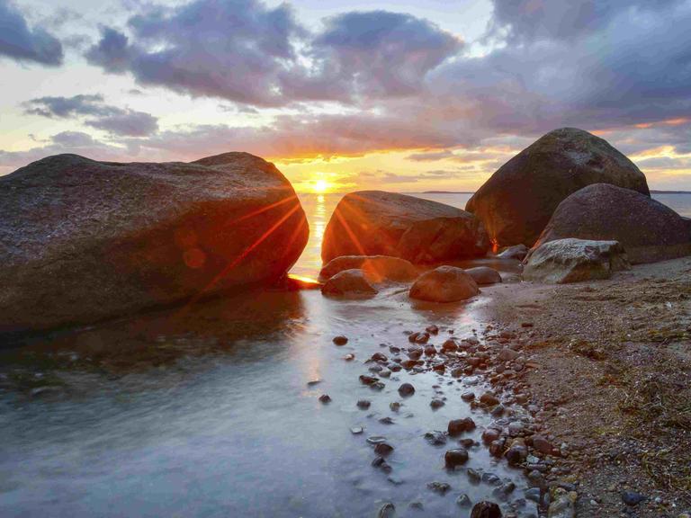 Große Findlinge am Strand der Ostsee bei Sonnenuntergang, Naturschutzgebiet Mönchgut, Groß Zicker, Insel Rügen.