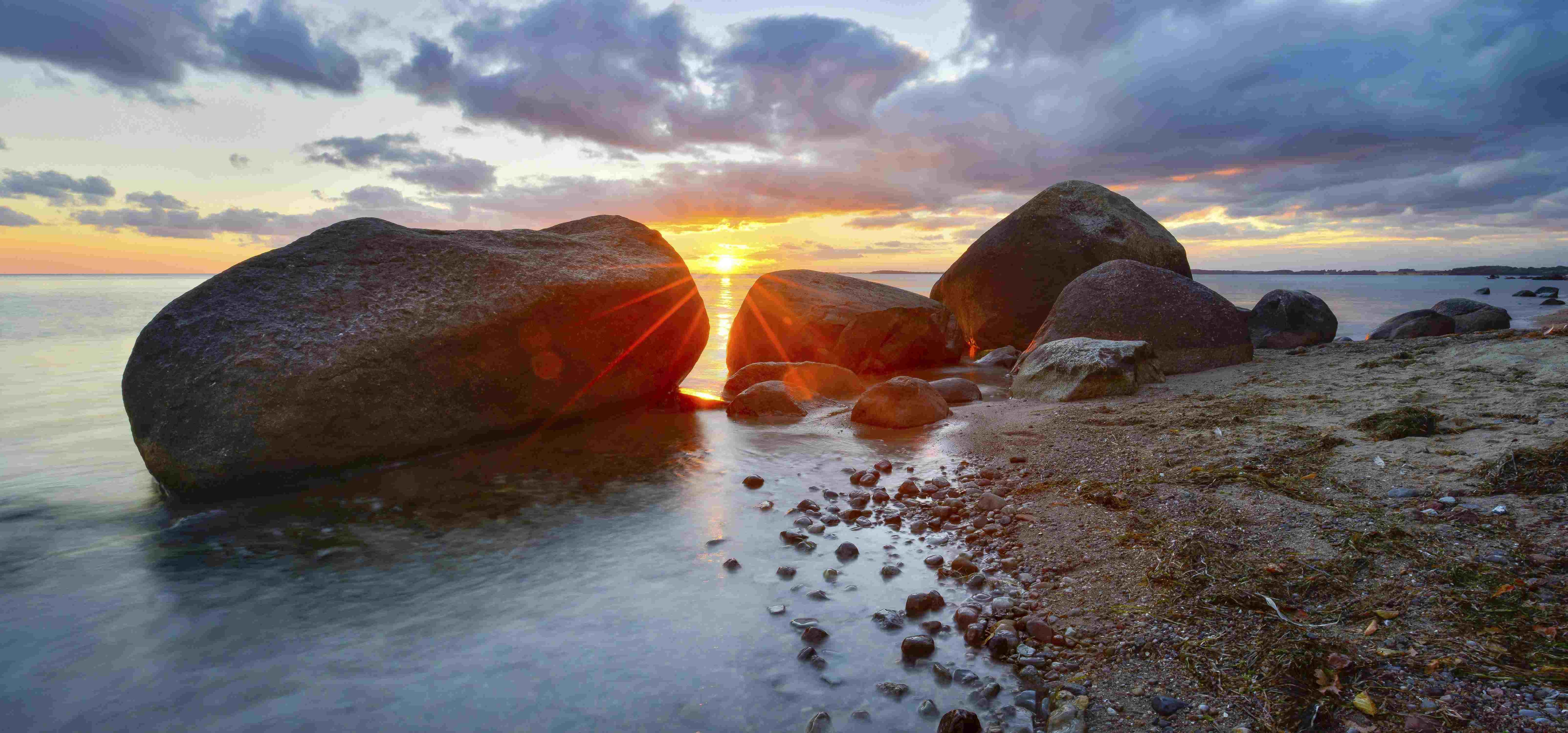 Große Findlinge am Strand der Ostsee bei Sonnenuntergang, Naturschutzgebiet Mönchgut, Groß Zicker, Insel Rügen.