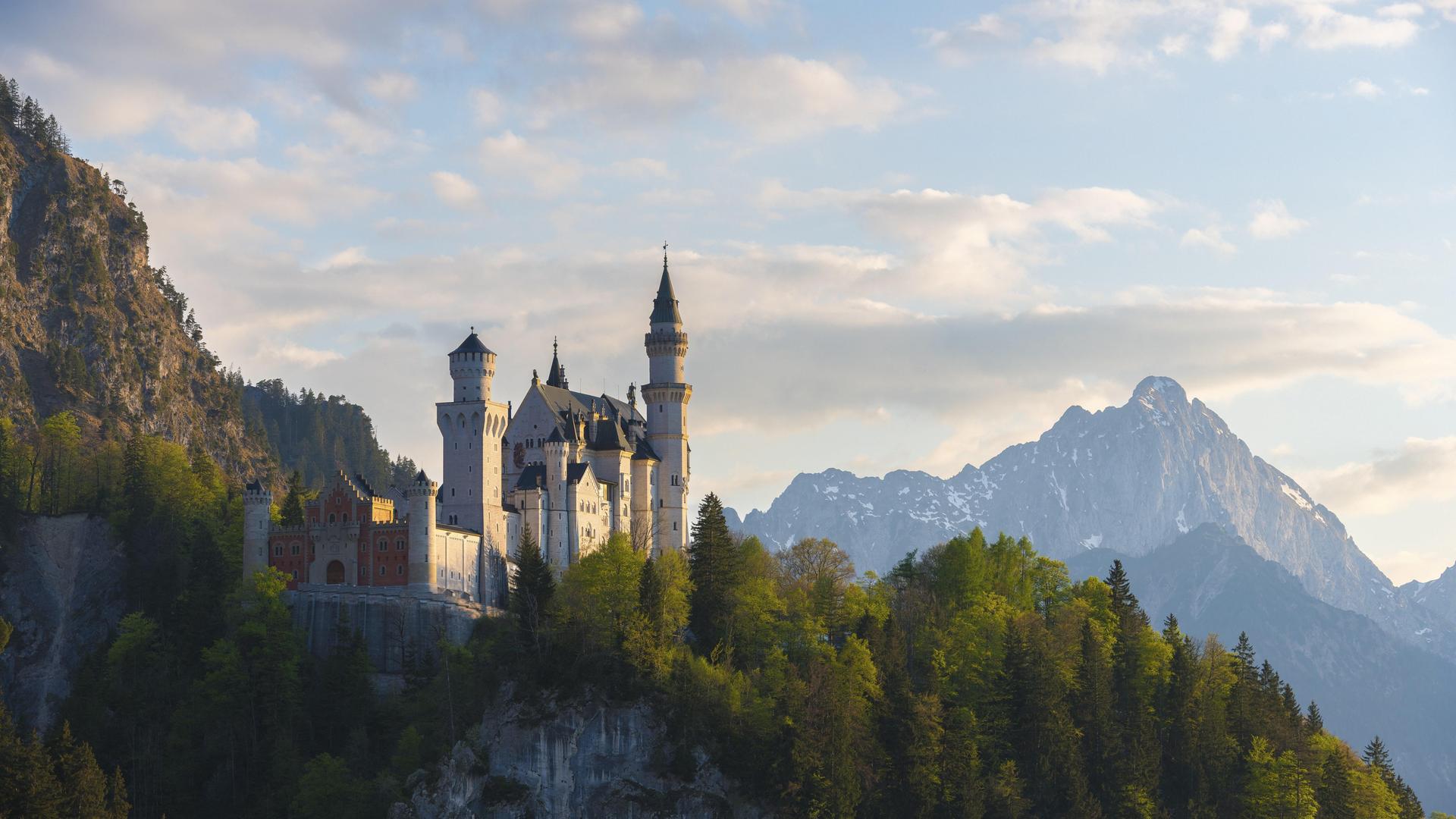 Romantisches Schloss vor Alpenkulisse bei Dämmerung, Neuschwanstein, Schwangau bei Füssen, Landkreis Ostallgäu in Bayern
