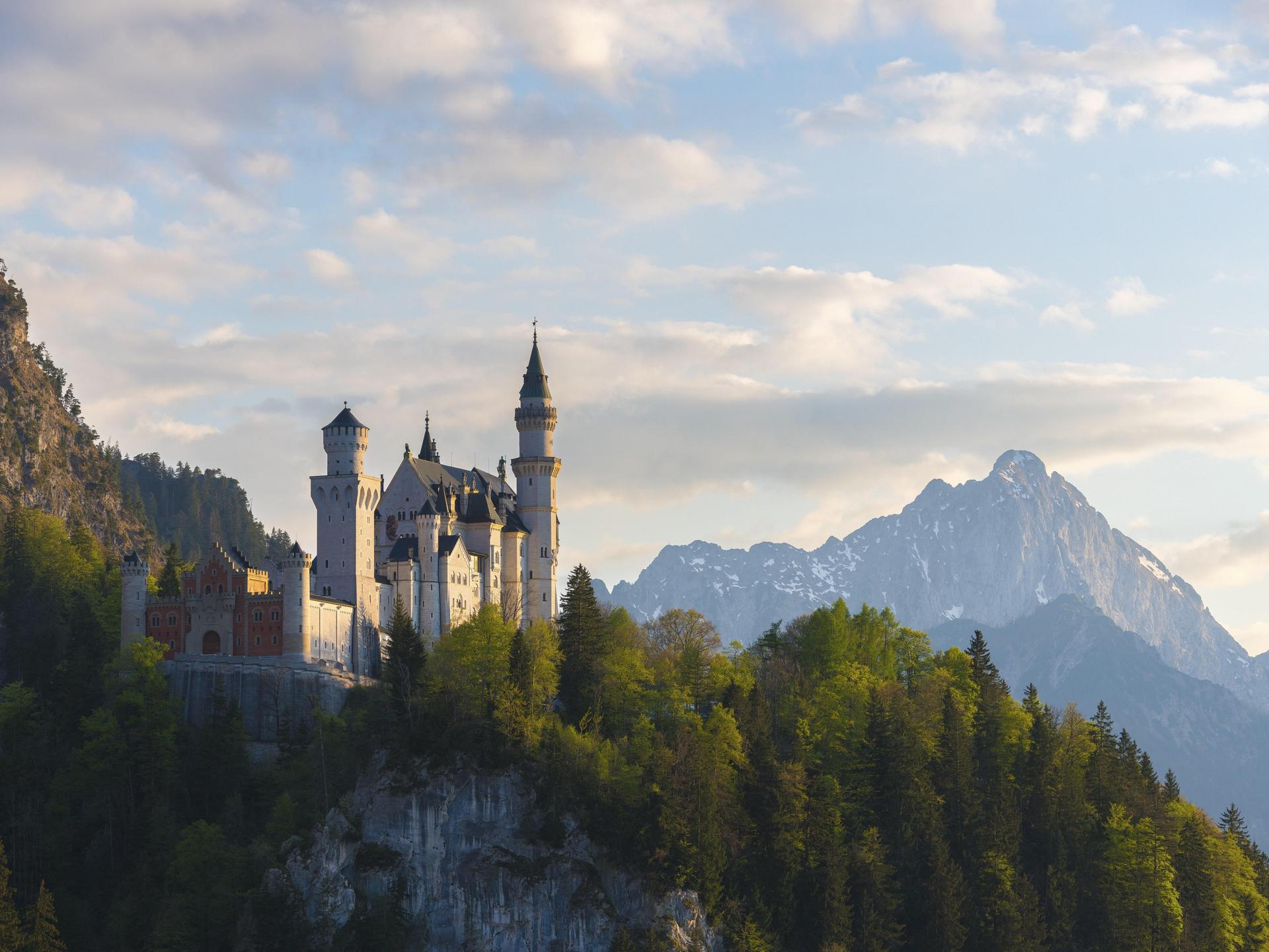 Romantisches Schloss vor Alpenkulisse bei Dämmerung, Neuschwanstein, Schwangau bei Füssen, Landkreis Ostallgäu in Bayern