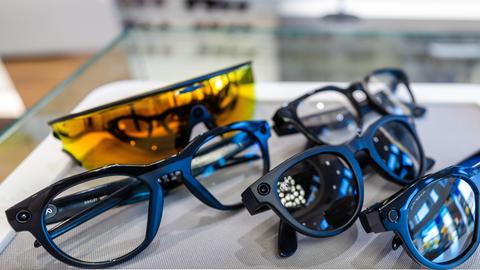 Mehrere Smart Glasses liegen nebeneinander. Einige sind blau eingefasst, eine leuchtend gelb.  