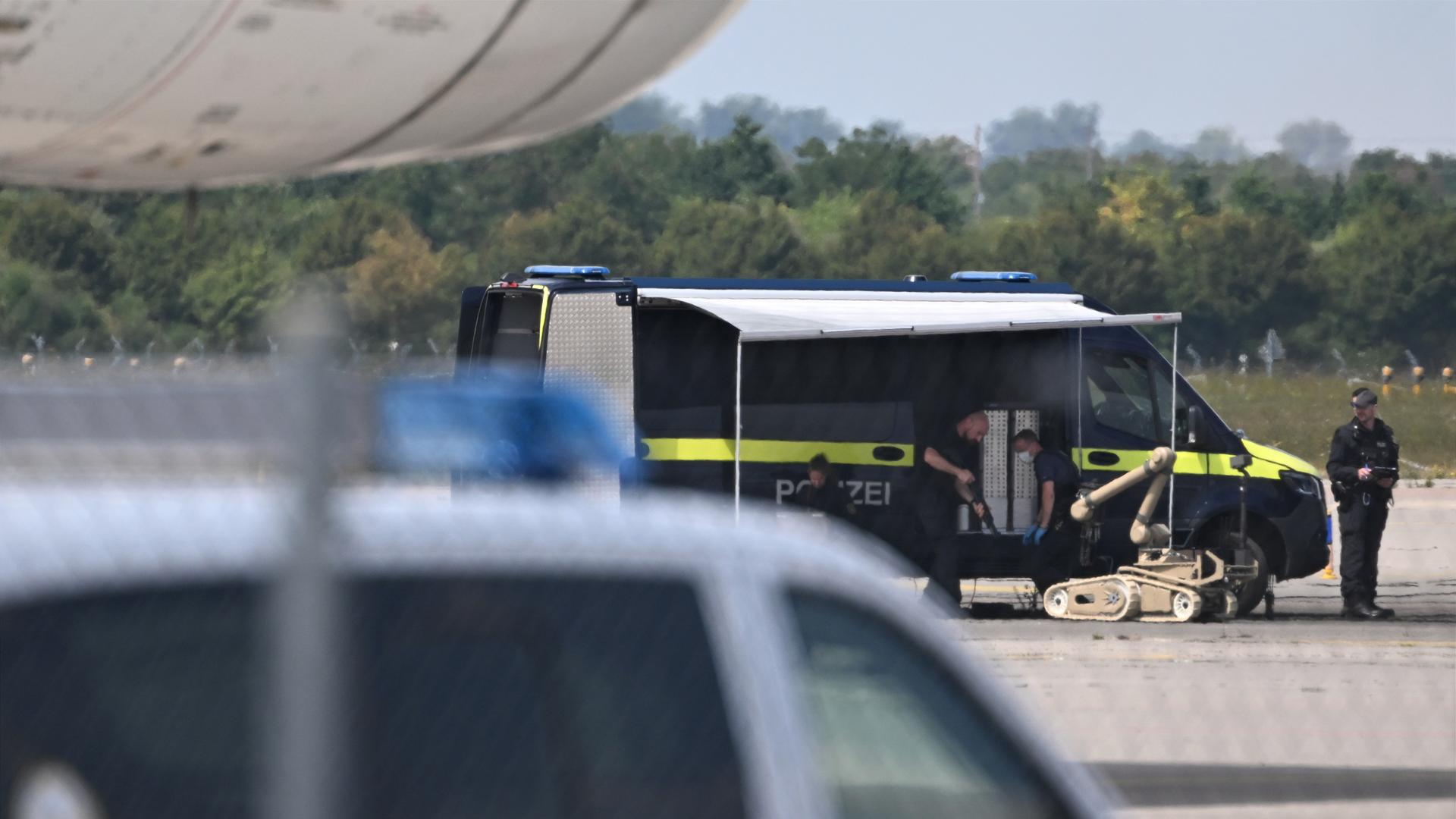 Kriminaltechniker der Polizei (hinten) bereiten den Einsatz eines Sprengroboters in der Nähe eines ukrainischen Flugzeugs auf dem Flughafen Leipzig/Halle vor. Kriminaltechniker der Polizei (hinten) bereiten den Einsatz eines Sprengroboters in der Nähe eines ukrainischen Flugzeugs auf dem Flughafen Leipzig/Halle vor.