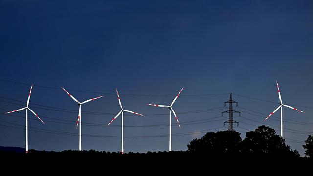 Blick auf einen tiefblauen Himmel mit strahlend weißen Windrädern.
