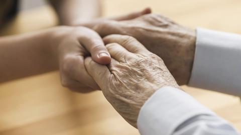 Hände einer jüngeren Frau halten die Hände eines älteren Mannesvorhanden