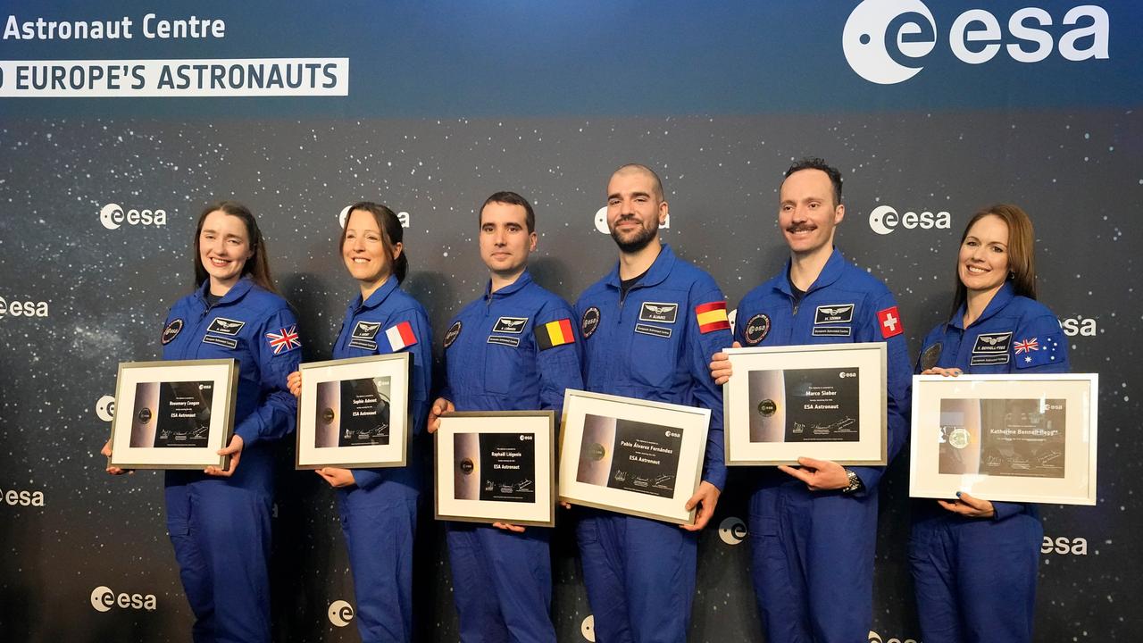 Die sechs neuen ESA-Astronauten stehen in einer Reihe und halten ihre Urkunden fest.