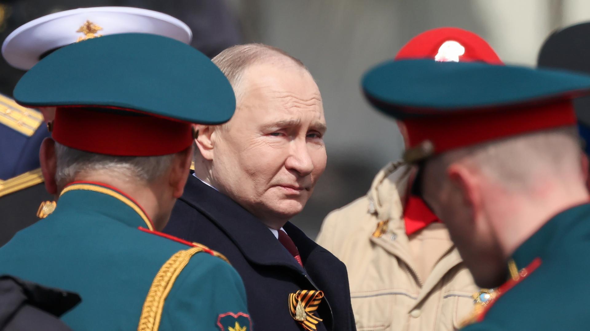Der russische Präsident Wladimir Putin steht zwischen hochrangigen Militärs.