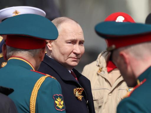 Der russische Präsident Wladimir Putin steht zwischen hochrangigen Militärs.