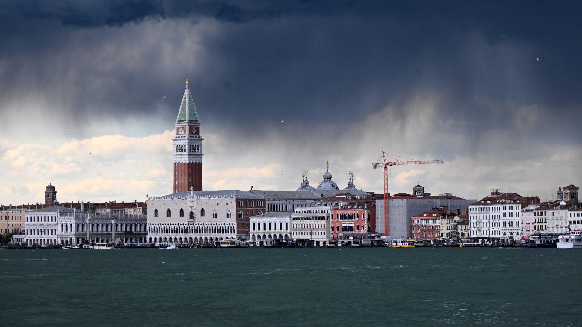 Dunkle Gewitterwolken über dem Markusturm und dem Meer von Venedig. 
