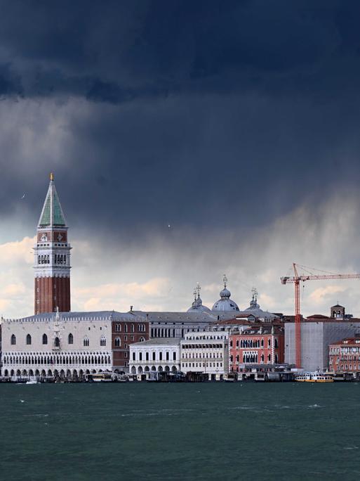 Dunkle Gewitterwolken über dem Markusturm und dem Meer von Venedig.