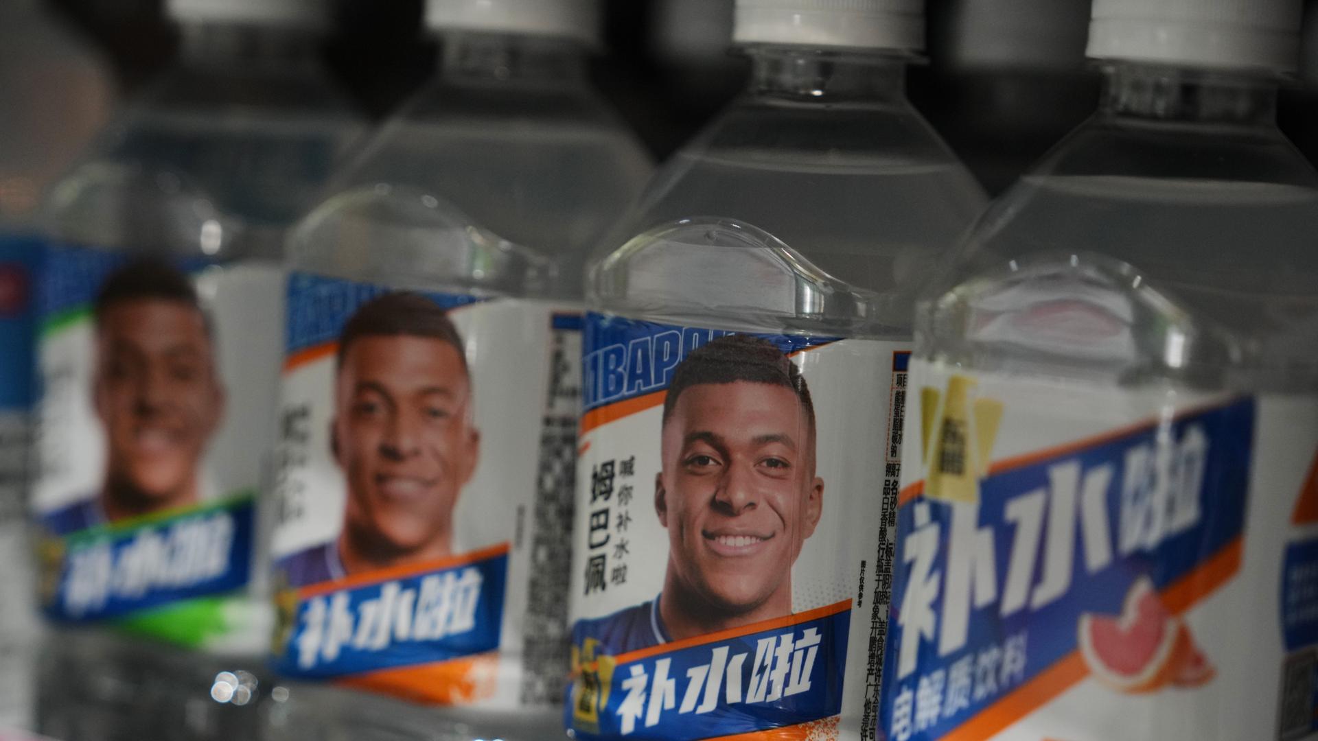 Getränkeflaschen in China, auf denen das Gesicht des französischen Fußballstars Kilian Mbappé abgebildet ist. 