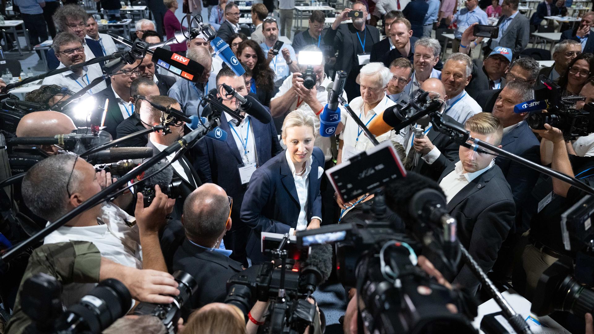 Alice Weidel auf einem Parteitag der AfD 2022, umringt Mikrofonen, Kameras und Journalisten