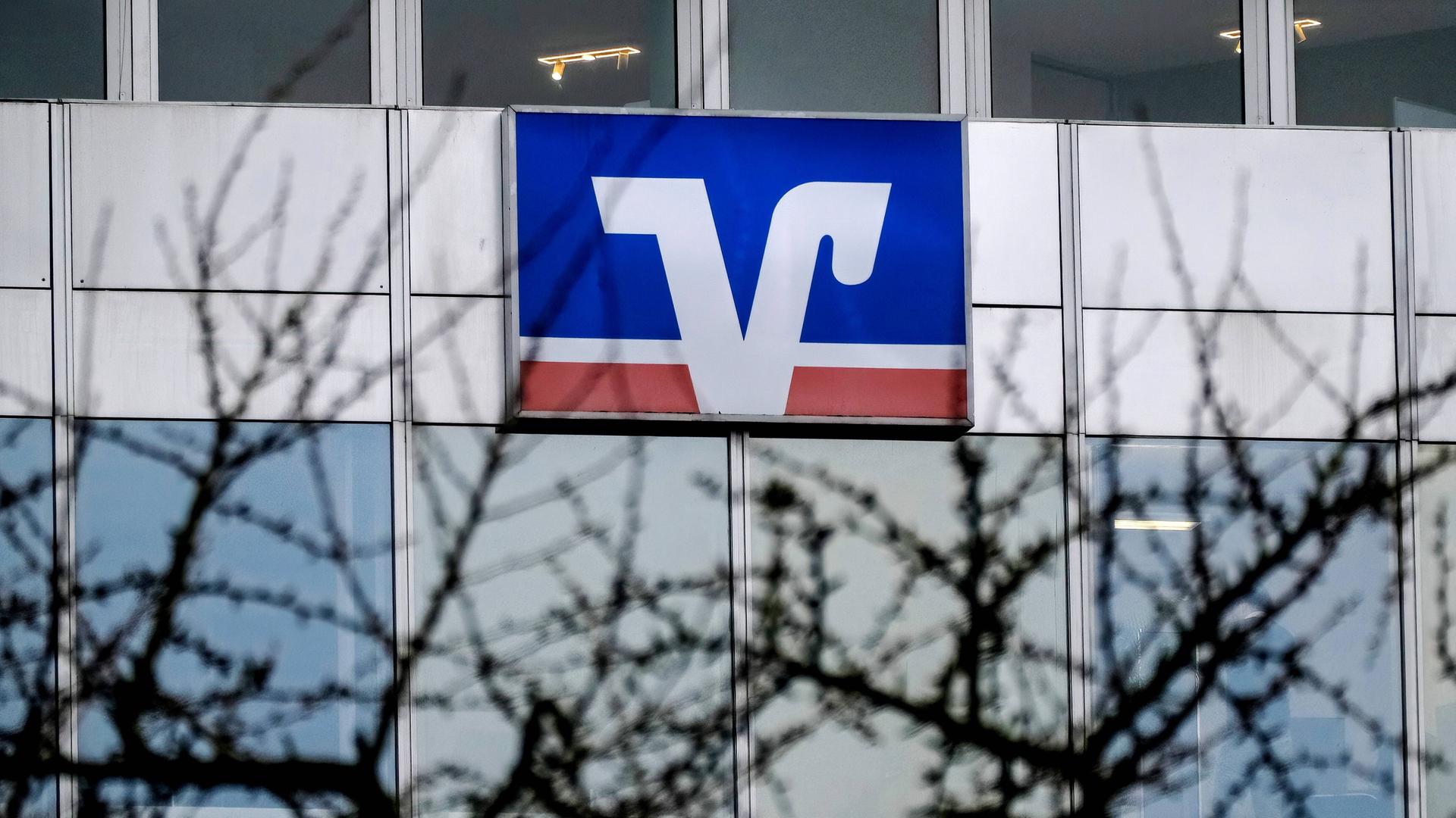 Das Logo der VR-Bank hängt an der Fassade eines Bürogebäudes.