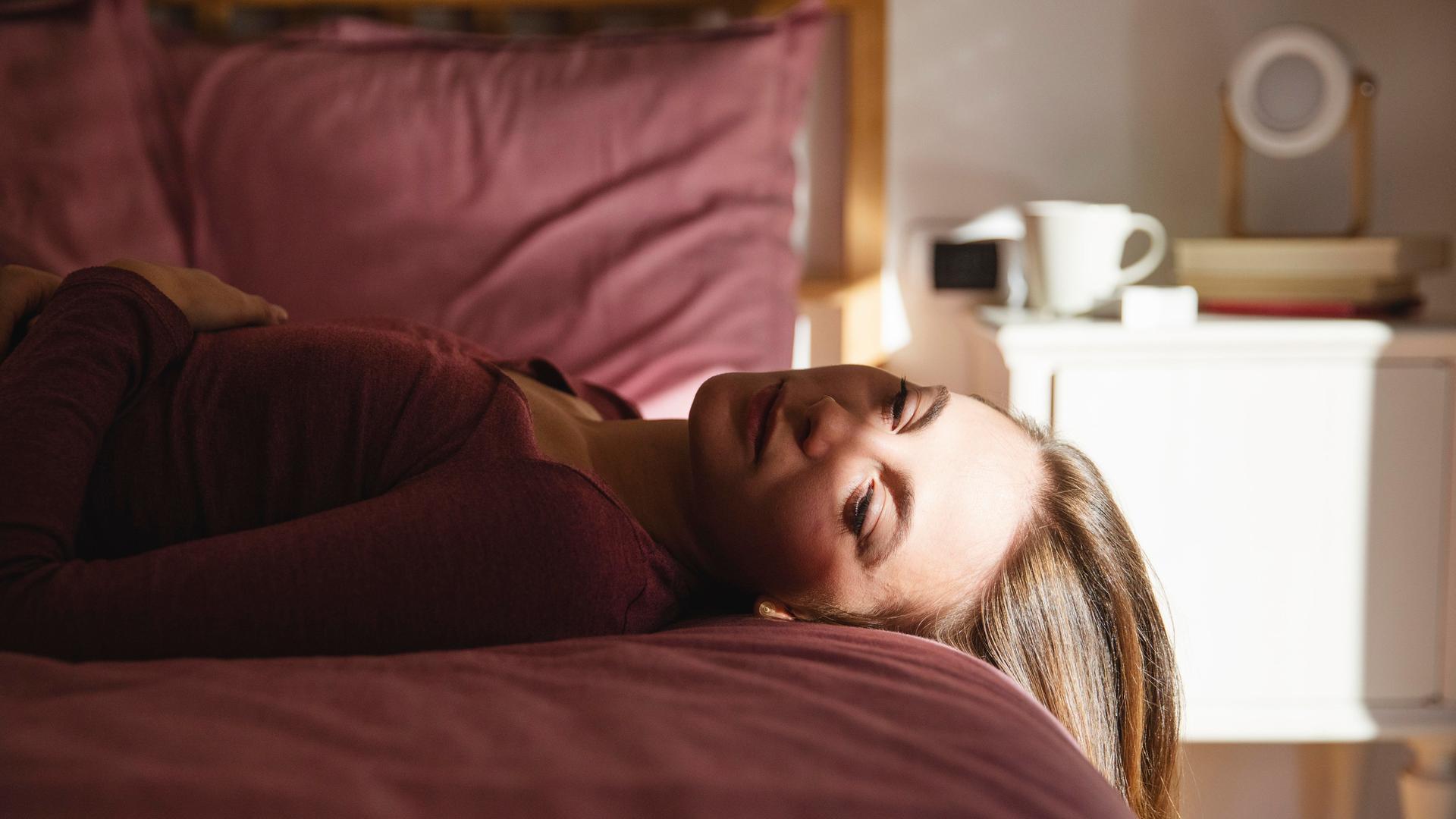 Frau liegt auf dem Bett. 