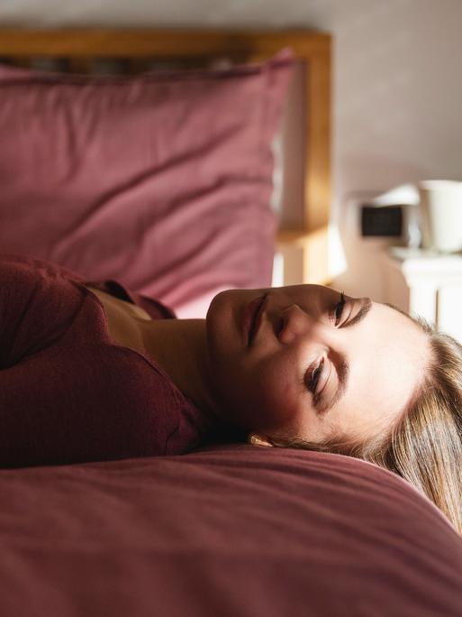 Frau liegt auf dem Bett. 