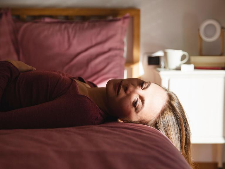 Frau liegt auf dem Bett. 