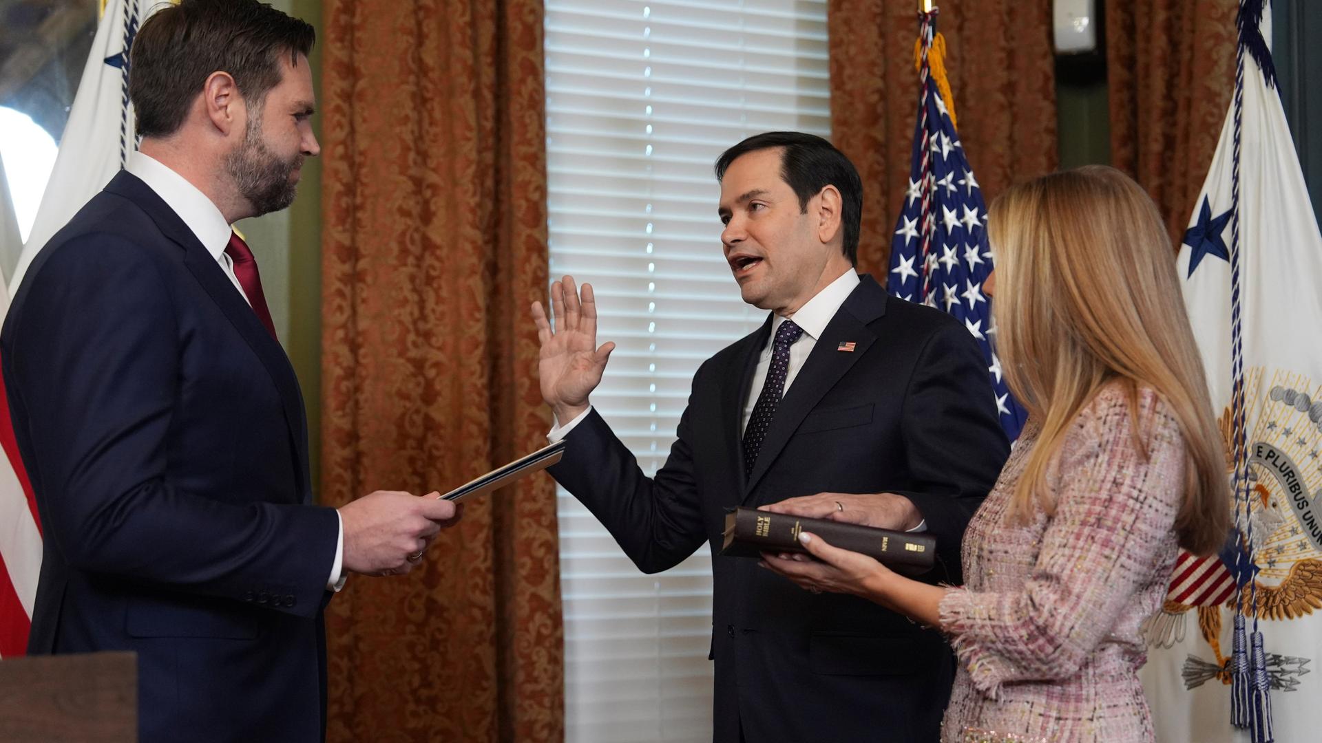 US-Außenminister Marco Rubio wird von Vizepräsident J.D. Vance vereidigt. Eine Hand hat er erhoben, die andere liegt auf einer Bibel. 