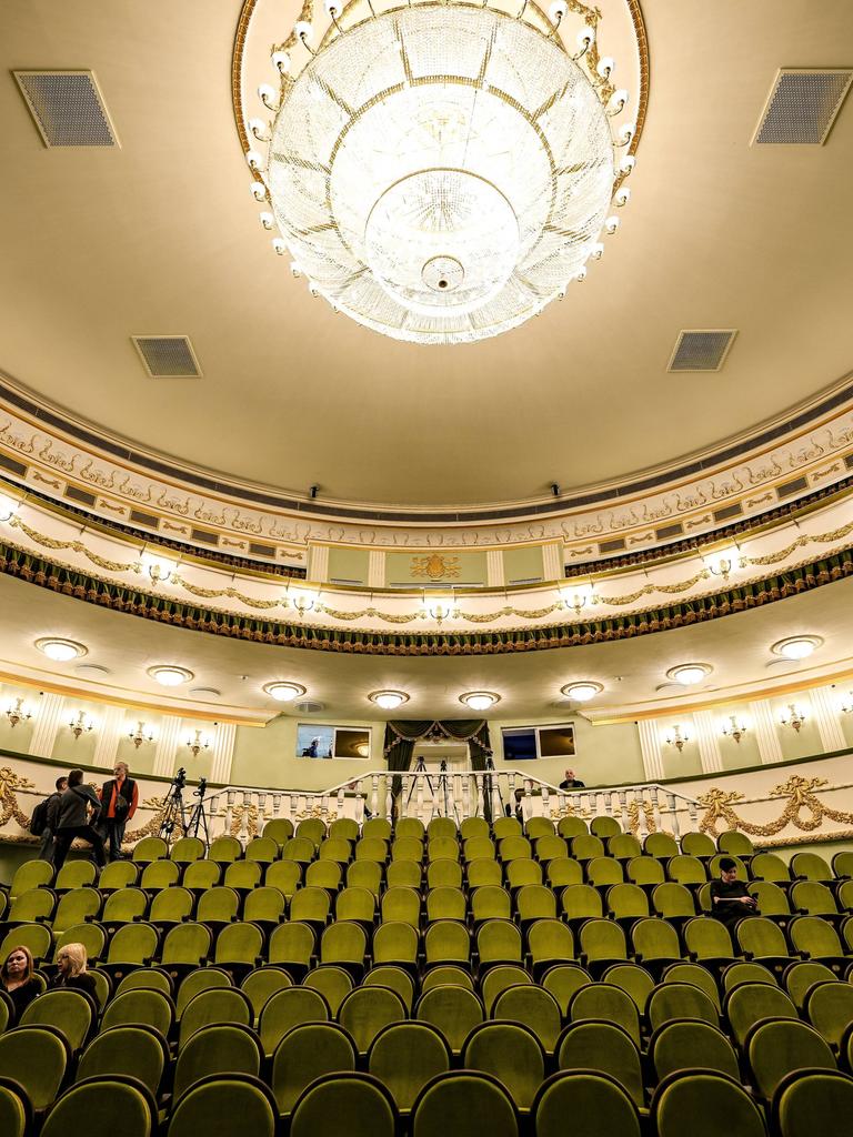 Blick in den festlich erleuchteten Zuschauersaal des Theaters von Mariupol mit grünen Sitzreihen und einem Kronleuchter