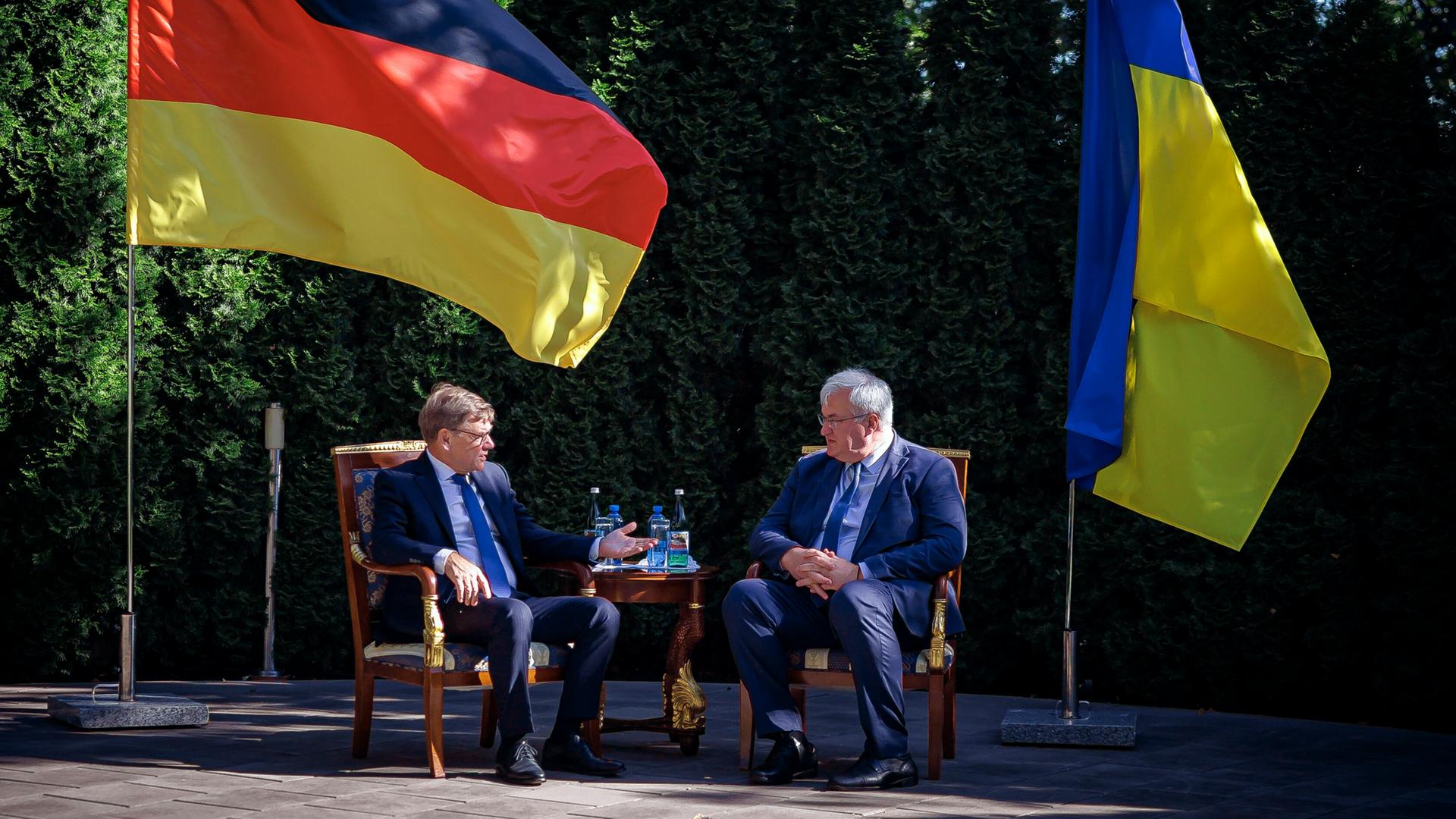Zu sehen sind Bundesaußenminister Wadephul und der ukrainische Außenminister Sybiha. Beide sitzen und unterhalten sich. Im Hintergrund die Landesflaggen von Deutschland und der Ukraine.