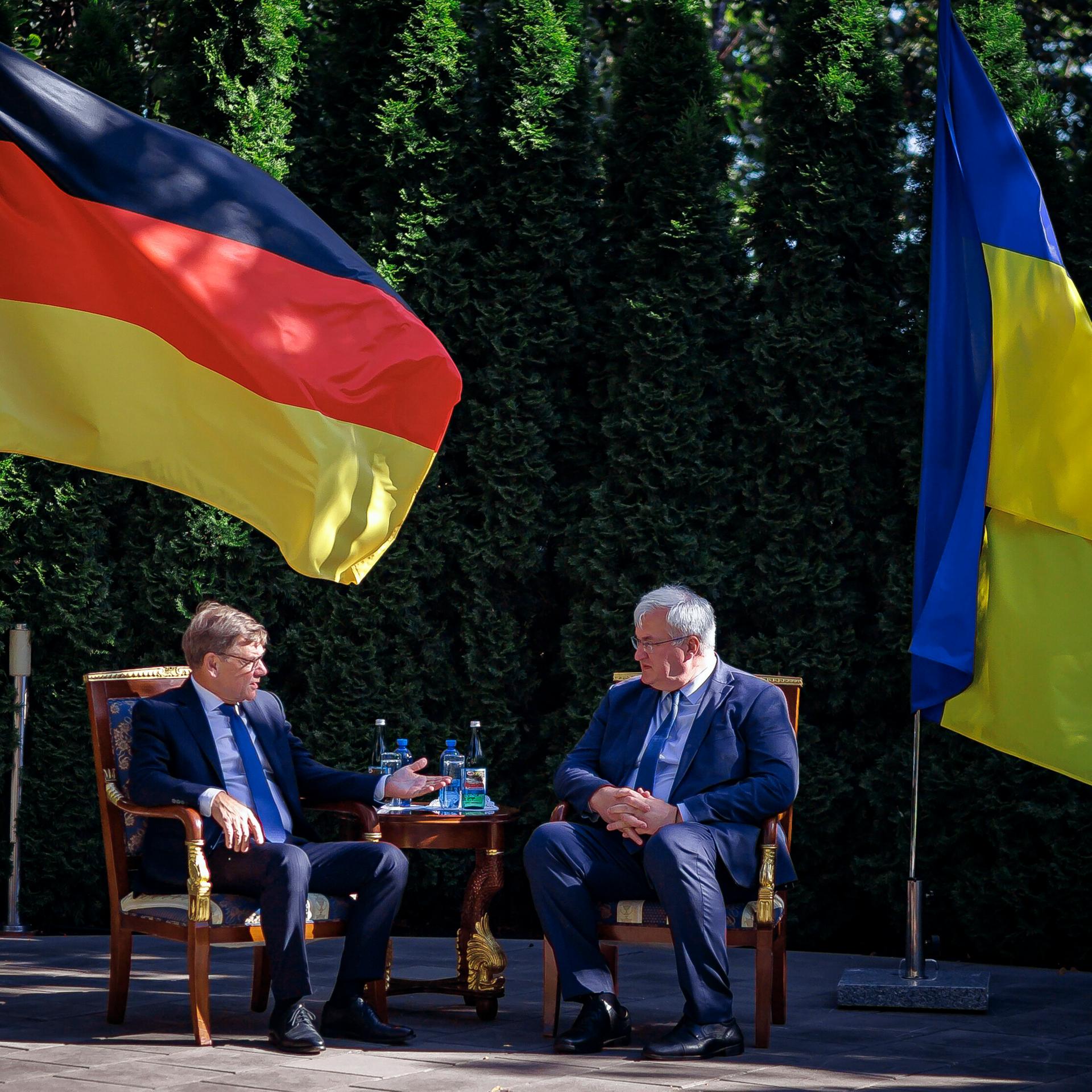 Zu sehen sind Bundesaußenminister Wadephul und der ukrainische Außenminister Sybiha. Beide sitzen und unterhalten sich. Im Hintergrund die Landesflaggen von Deutschland und der Ukraine.