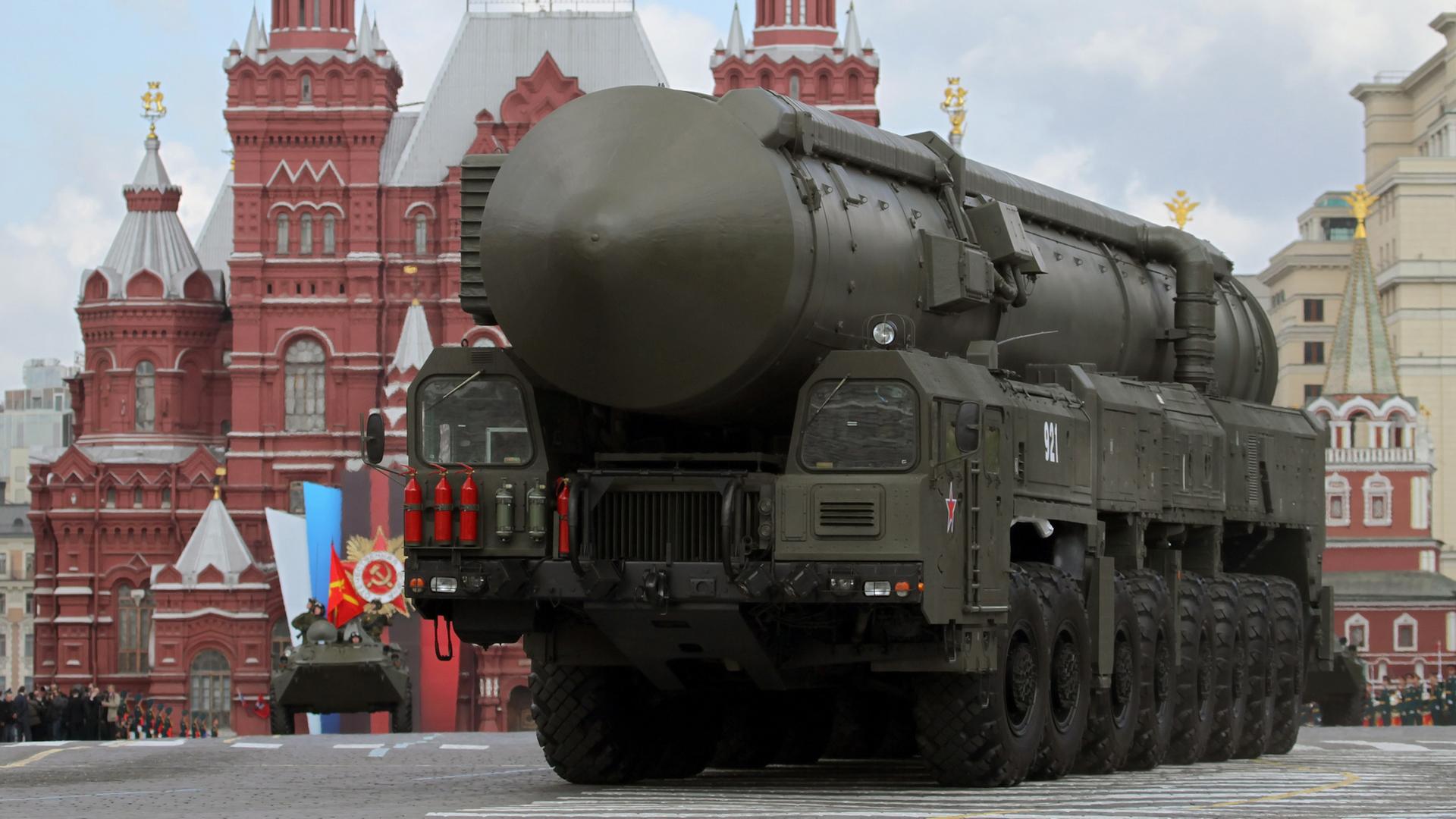 Die riesige Rakete ist auf einem Militärfahrzeug montiert und fährt an einem Kreml-Gebäude vorbei.