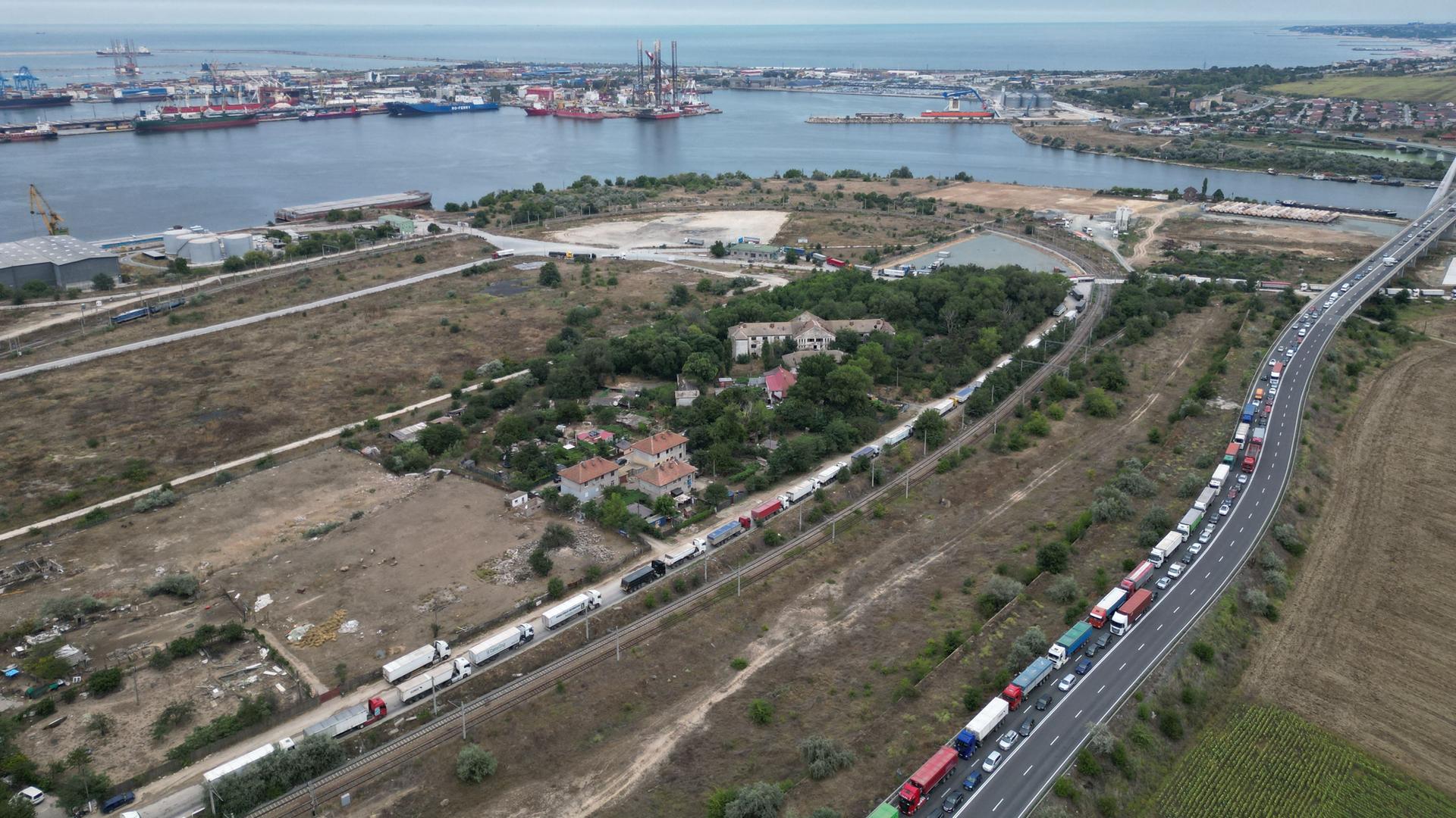 Blick über den Frachthafen von Constanta in Rumänien. Am rechten Bildrand eine lange Schlange mit wartenden Lkw's.