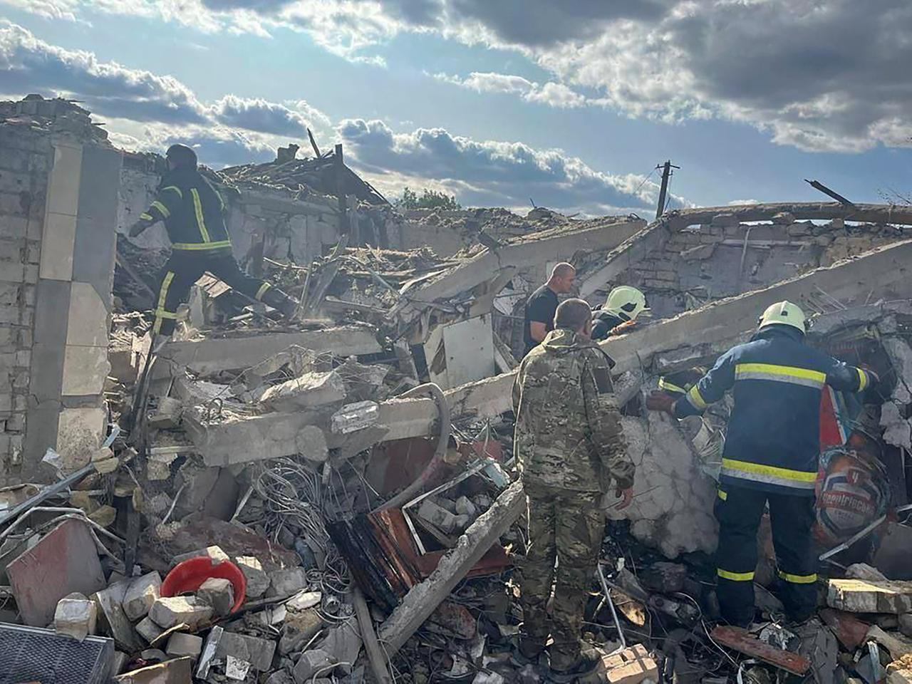 Auf diesem vom Pressebüro des ukrainischen Präsidenten zur Verfügung gestellten Foto suchen Rettungskräfte nach Opfern eines russischen Raketenangriffs, bei dem nach Angaben der Regierung in Kiew mindestens 47 Menschen in dem Dorf Hroza in der Nähe von Charkiw getötet wurden.