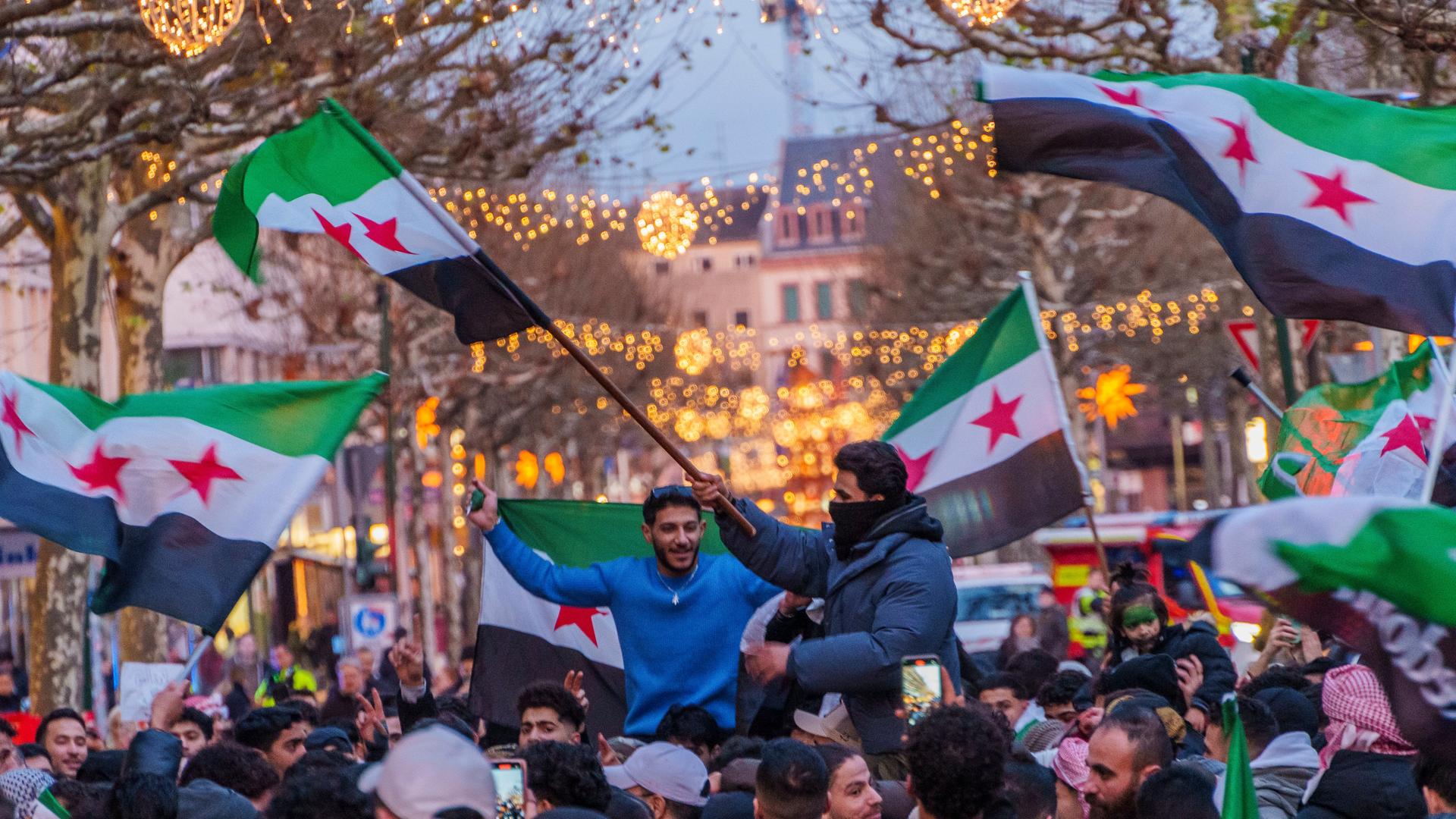 Syrer feiern auf dem Schillerplatz und der Ludwigstraße in Mainz den Sturz des Assad-Regime. Sie schwenken Fahnen und jubeln. 