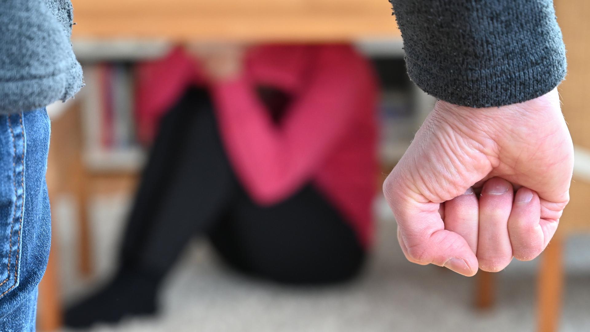 Eine Frau versucht, sich vor der Gewalt eines Mannes zu schützen (gestellte Szene).