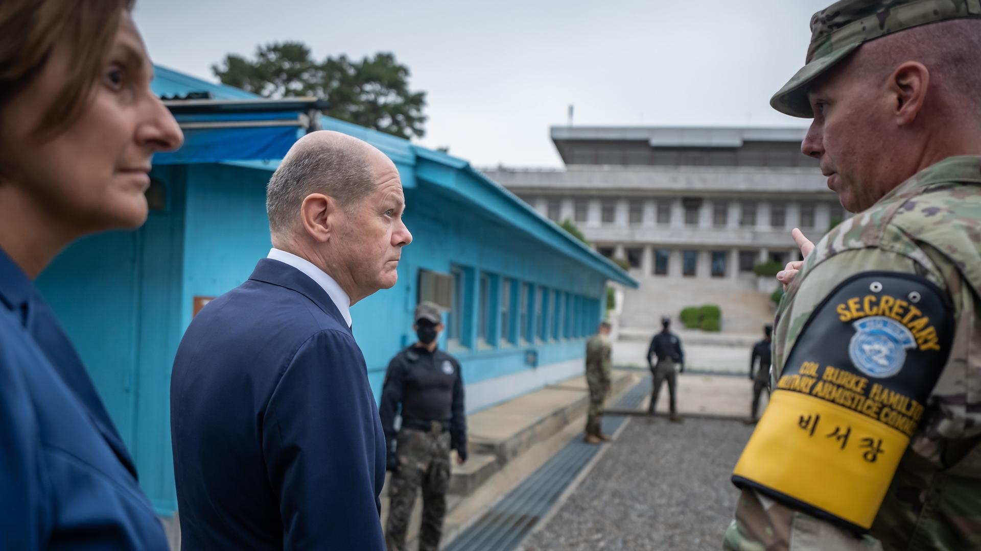 Bundeskanzler Olaf Scholz (SPD), und seine Frau Britta Ernst sprechen mit Burke Hamilton, kommandierender Offizier der Waffenstillstandskommission beim Besuch der entmilitarisierten Zone an der Grenze zu Nordkorea. 