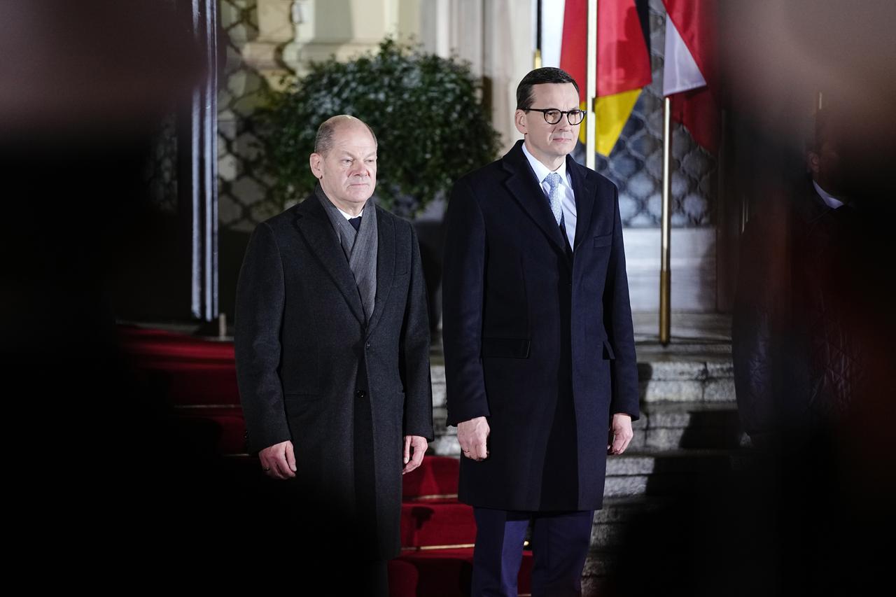 Bundeskanzler Scholz und Polens Regierungschef Morawiecki vor den Flaggen der beiden Ländern auf einem roten Teppich.