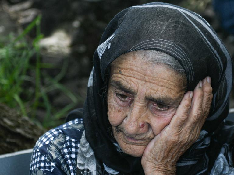 Elena Gardashyan, 97, die älteste Einwohnerin von Kirants in der armenischen Provinz Tawusch. Sie hat eine Hand auf ihre Wange gelegt, trägt ein Kopftuch und schaut resigniert schräg auf den Boden.