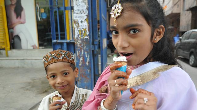 Kinder sind festlich gekleidet und essen ein Eis.