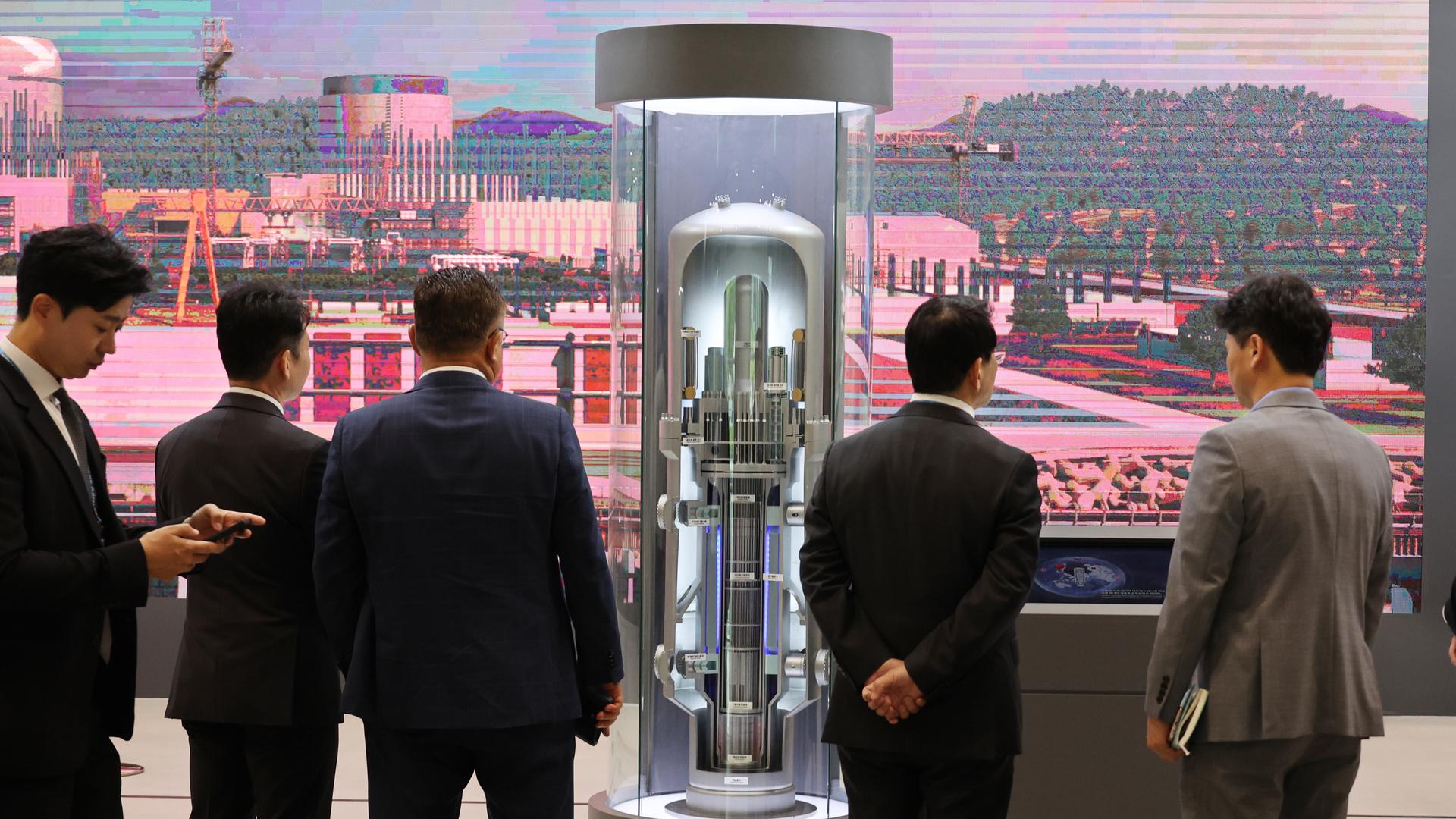 Besucher einer Messe für Nuklearenergie blicken auf das Modell eines Small Modular Reactor (SMR) in der südkoreanischen Hafenstadt Busan. Das Modell ist ca. 2 Meter hoch.