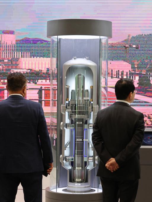 Besucher einer Messe für Nuklearenergie blicken auf das Modell eines Small Modular Reactor (SMR) in der südkoreanischen Hafenstadt Busan. Das Modell ist ca. 2 Meter hoch.