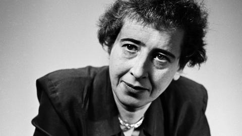 Schwarzweißaufnahme von Hannah Arendt in legerer Pose, die lakonisch ins Off schaut Schwarzweißaufnahme von Hannah Arendt in legerer Pose, die lakonisch ins Off schaut