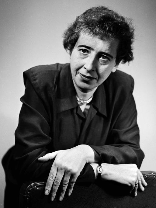 Schwarzweißaufnahme von Hannah Arendt in legerer Pose, die lakonisch ins Off schaut