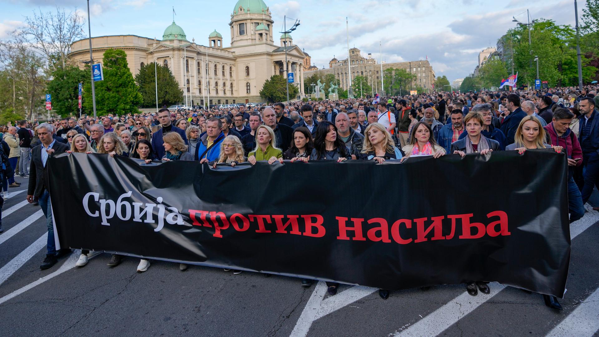 Menschen halten ein Transparent mit der Aufschrift "Serbien gegen Gewalt" während einer Demonstration vor dem Parlament in Belgrad.