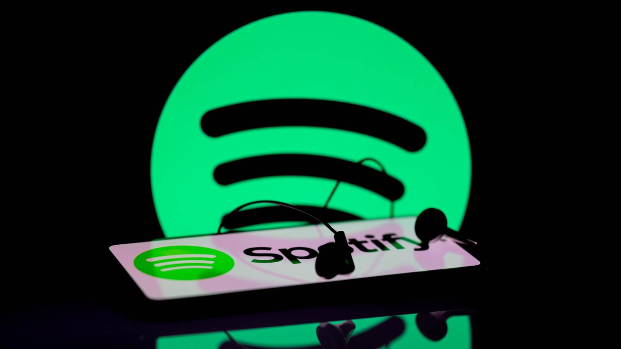 Das Spotify-App wird auf einem Smartphone angezeigt. Im Hintergrund ist das Spotify-Symbol zu sehen.