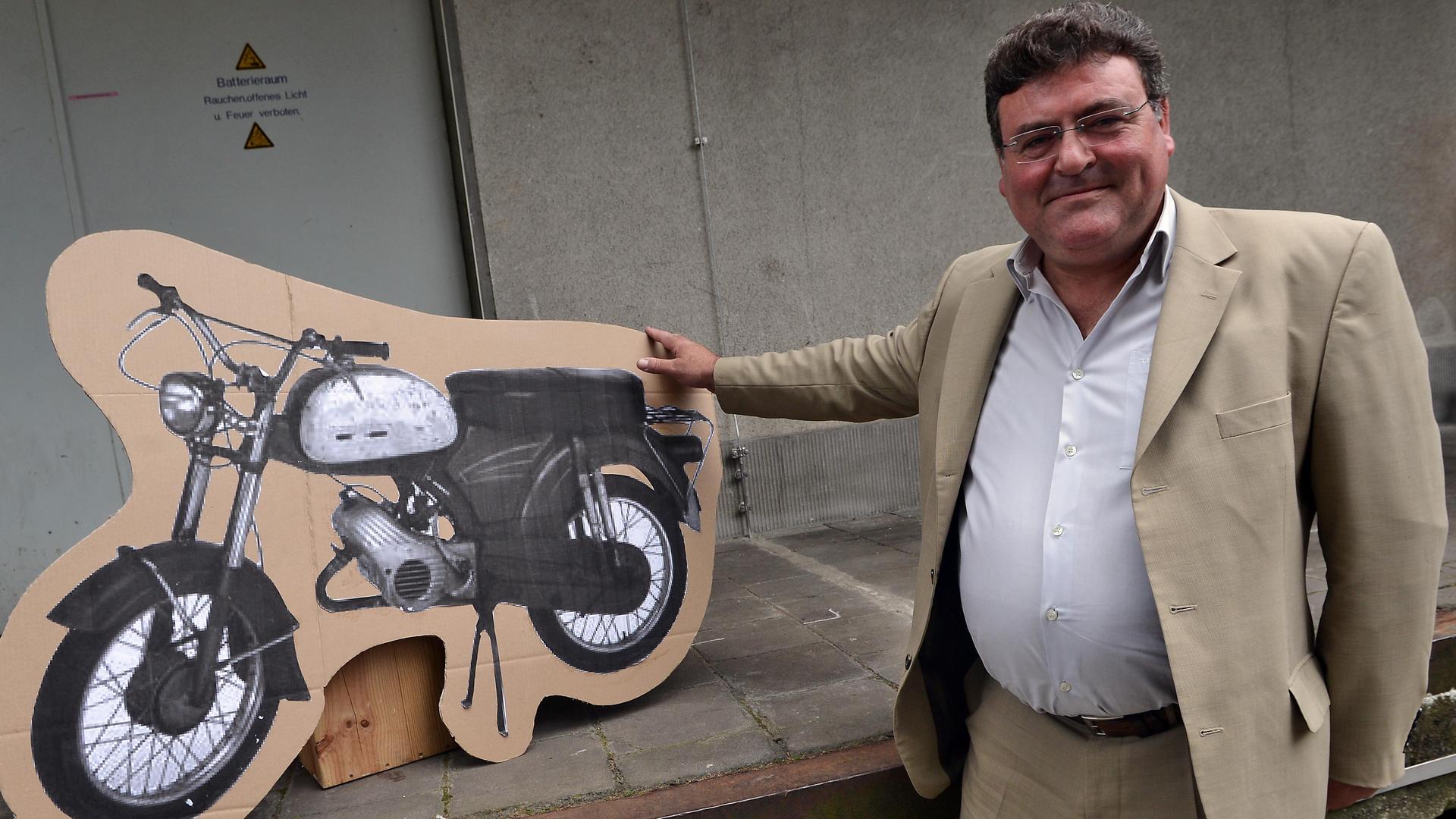 Der Enkel des Portugiesen Armando Rodrigues de Sá posiert am 13.09.2014 in Köln mit einem Bild des Mopeds, welches sein Großvater 1964 geschenkt bekam. 