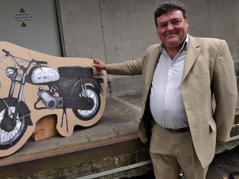 Der Enkel des Portugiesen Armando Rodrigues de Sá posiert am 13.09.2014 in Köln mit einem Bild des Mopeds, welches sein Großvater 1964 geschenkt bekam. 