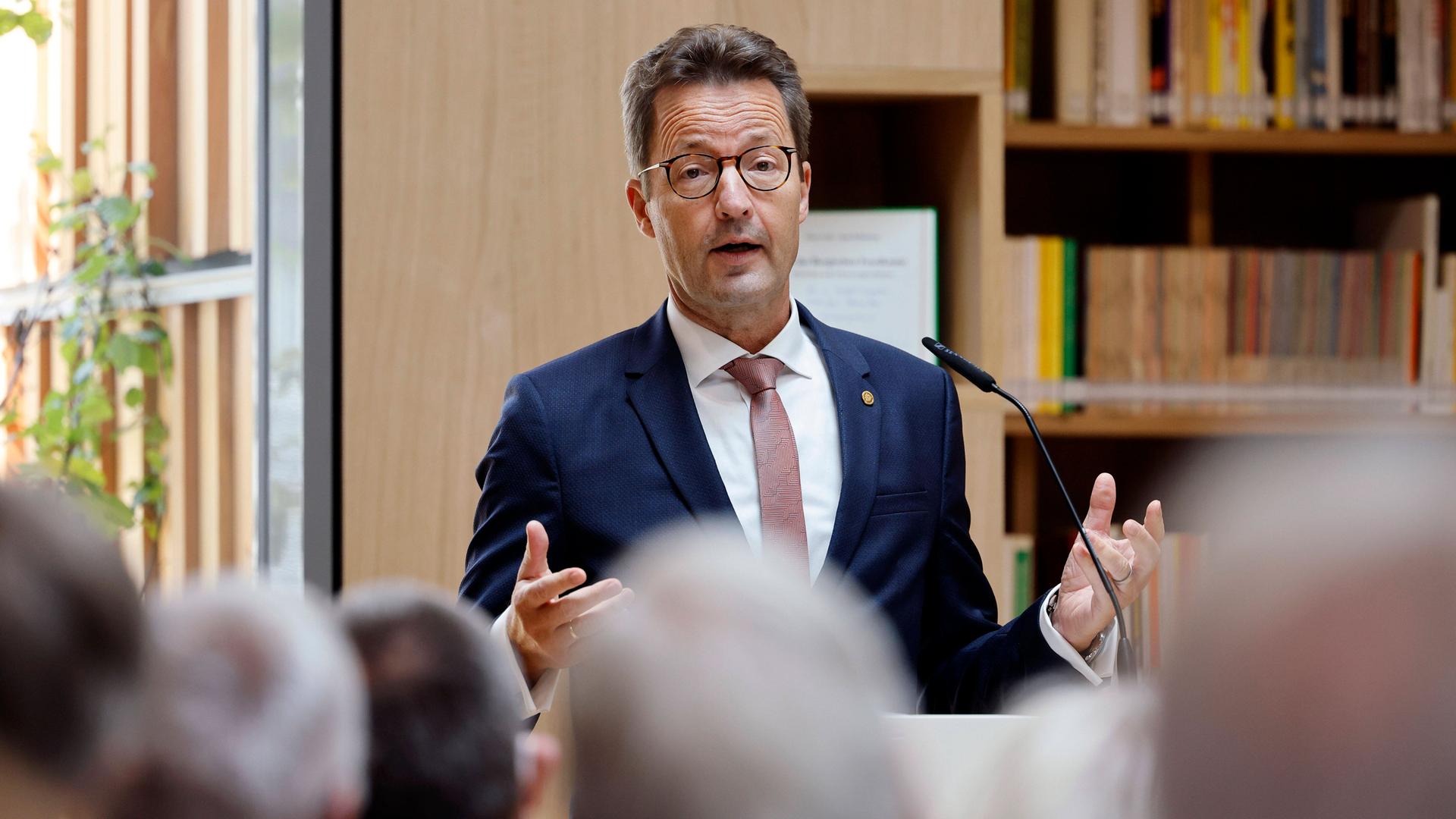 Der Präsident des Deutschen Hochschulverbands, Lambert T. Koch steht an einem Pult und hält eine Rede. Im Vordergrund sieht man die Köpfe seiner Zuhörer.