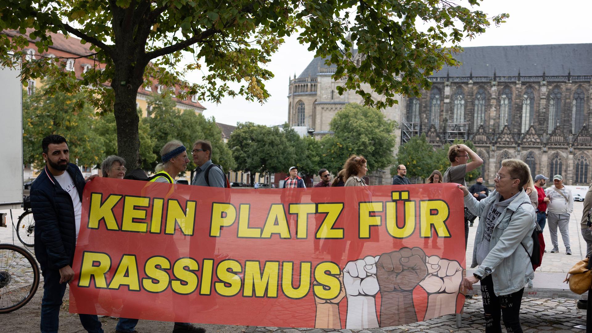 Migranten protestieren in Magdeburg gegen die AfD. Zu sehen ist ein großes Plakat, auf dem steht: "Kein Platz für Rassismus". Migranten protestieren in Magdeburg gegen die AfD. Zu sehen ist ein großes Plakat, auf dem steht: "Kein Platz für Rassismus".